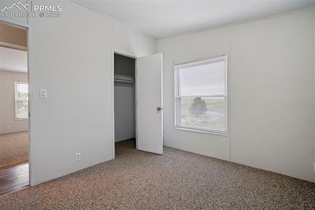 20150 Enoch Road Colorado Springs, CO 80928 - Photo 32 of 50 Unfurnished bedroom featuring carpet flooring and a closet