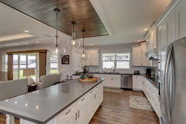 a large kitchen with stainless steel appliances granite countertop a sink a stove and refrigerator