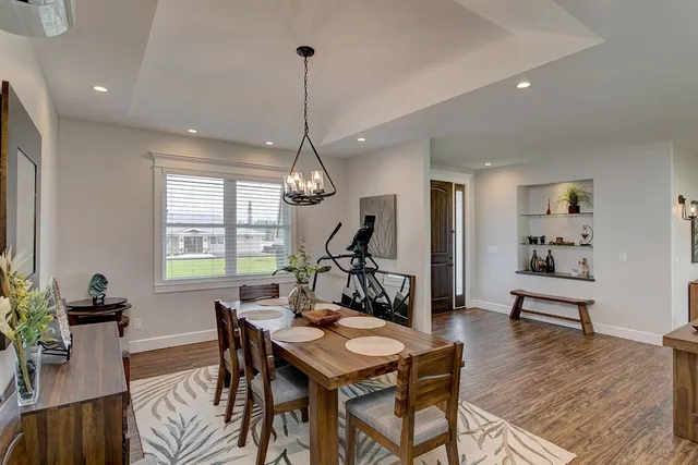 a view of a livingroom and dining room with furniture wooden floor a chandelier