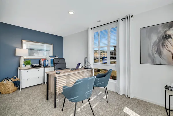a view of a workspace with furniture and a window