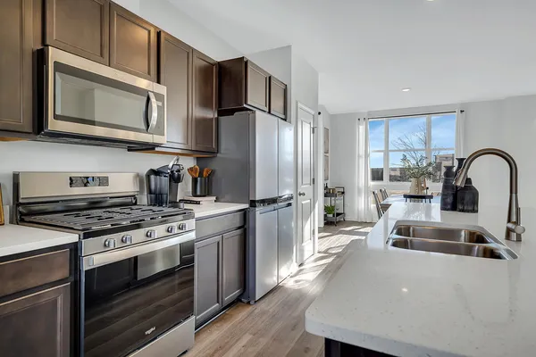 a kitchen with stainless steel appliances granite countertop a stove a sink and a refrigerator