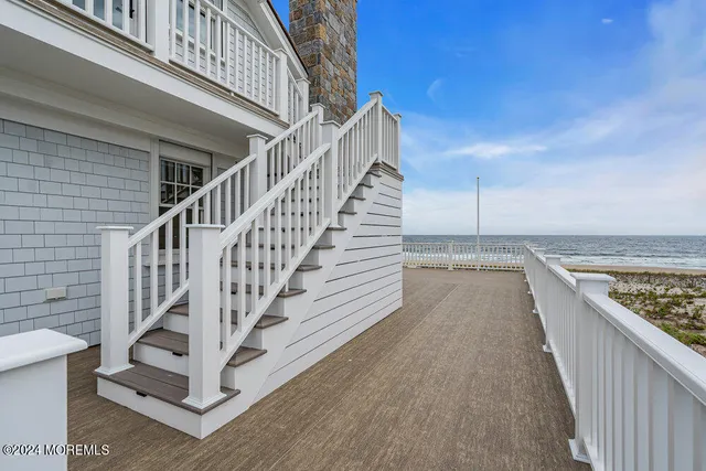 a view of an empty room with wooden floor fireplace and a window