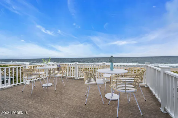 a living room with couches a flat screen tv and kitchen view