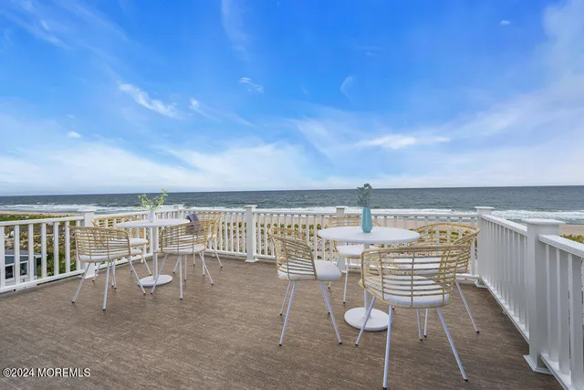 a living room with couches a flat screen tv and kitchen view