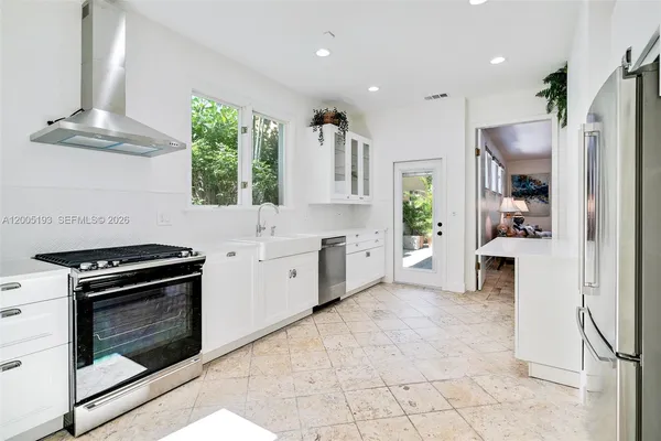 a kitchen with stainless steel appliances granite countertop a stove a sink and a refrigerator