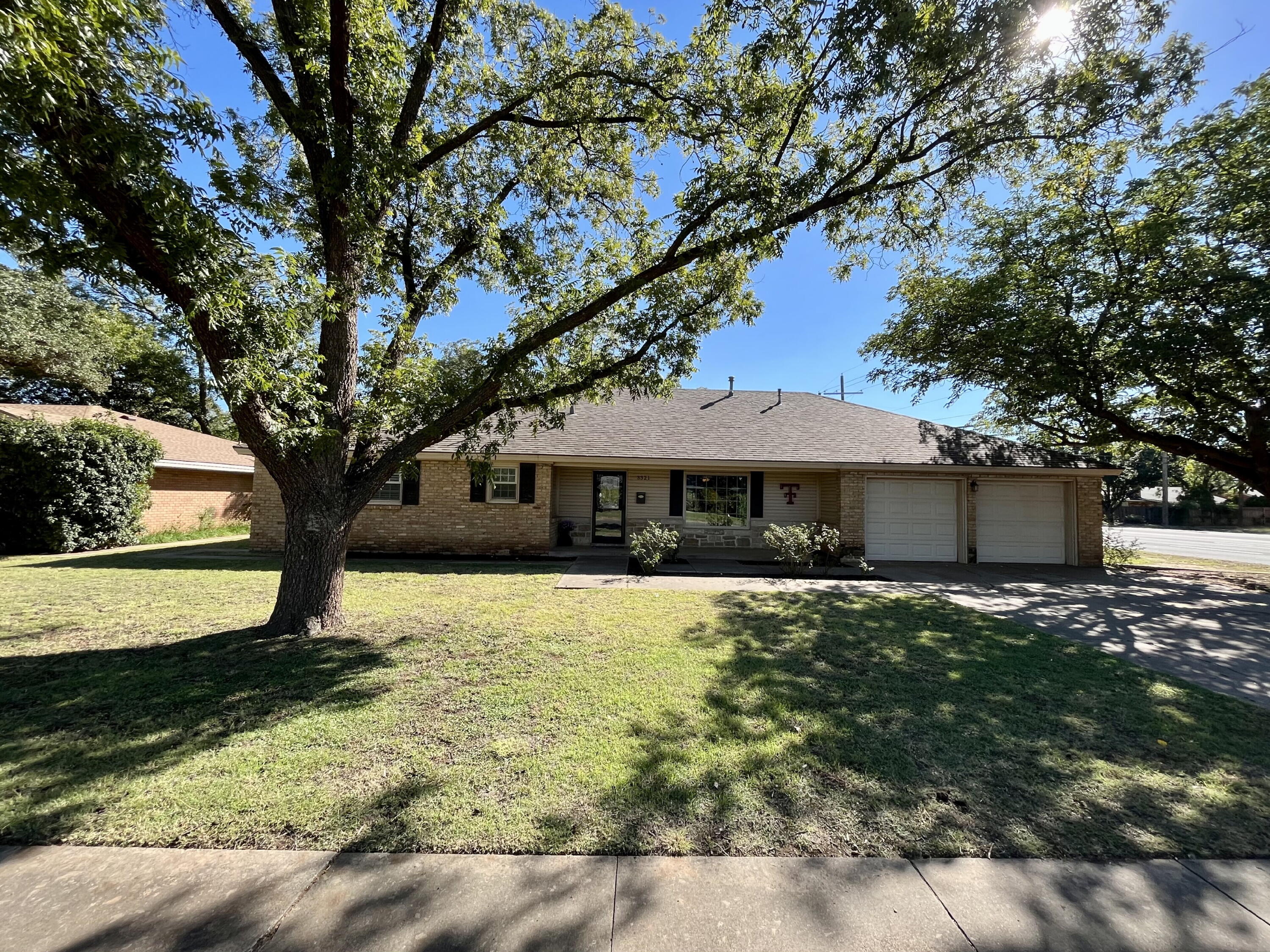 3321 55th Street Lubbock, TX 79413 - Photo 1 of 26 a front view of a house with garden
