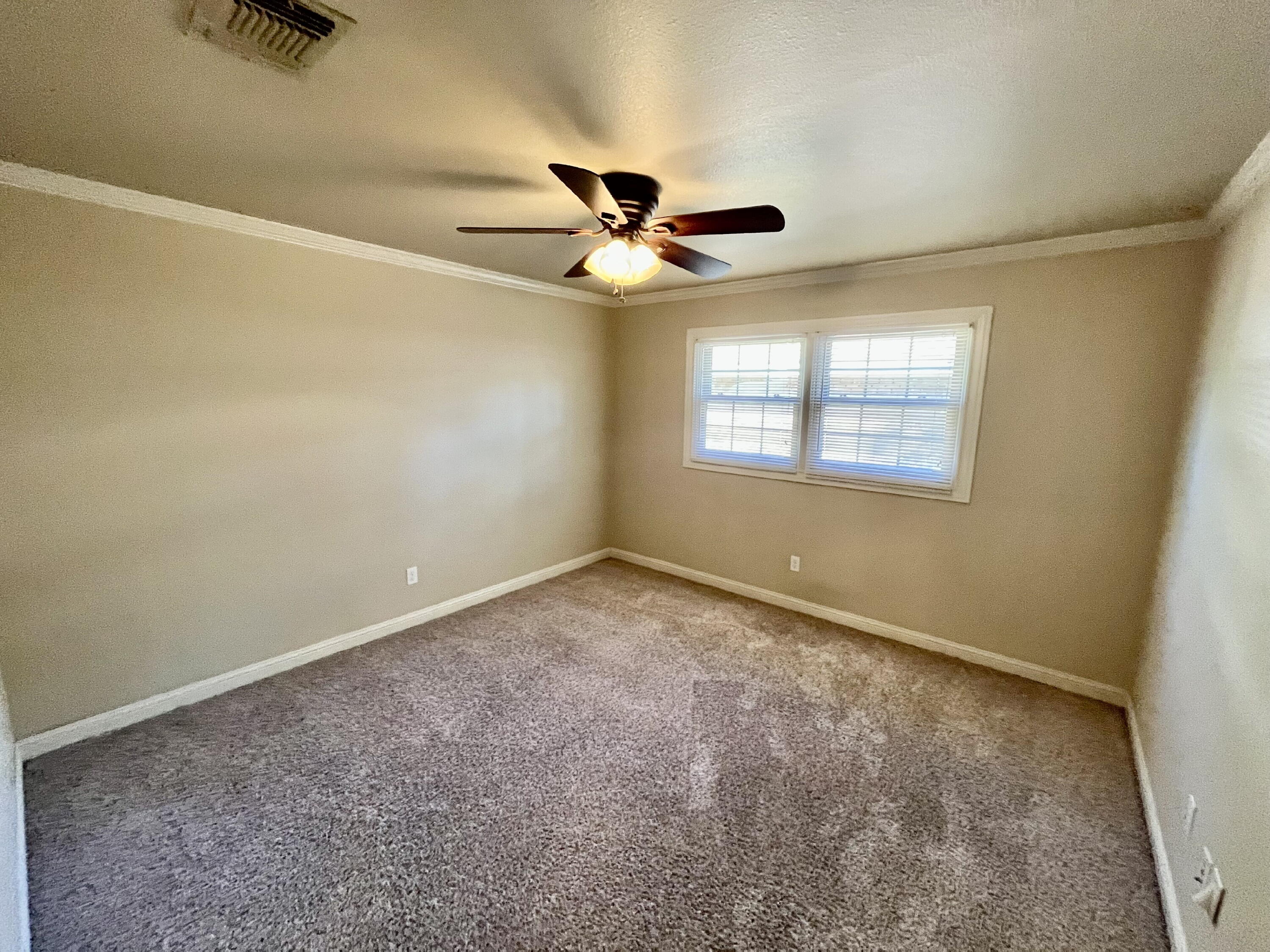 3321 55th Street Lubbock, TX 79413 - Photo 13 of 26 an empty room with a window and a fan