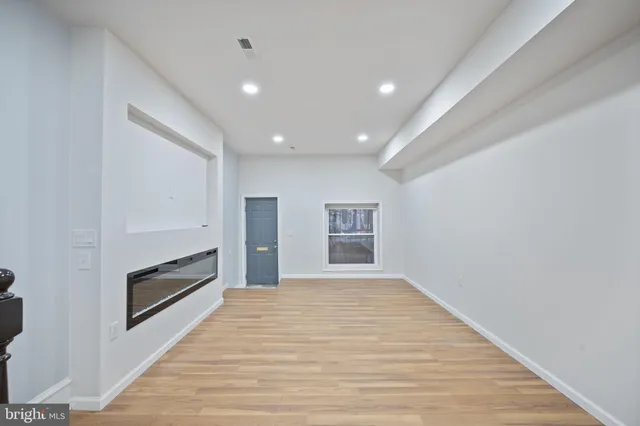 a view of empty room with wooden floor