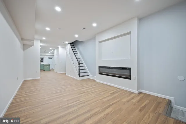 a view of a hallway with stairs and wooden floor