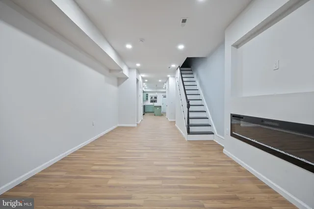 a view of a hallway with wooden floor and staircase