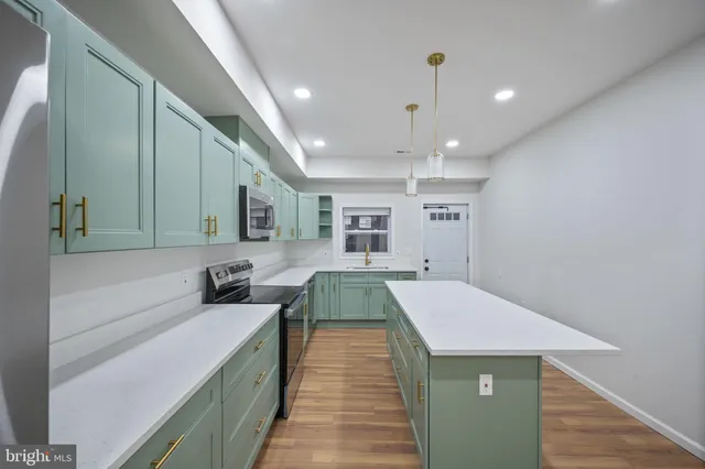 a kitchen with kitchen island a sink stainless steel appliances and cabinets