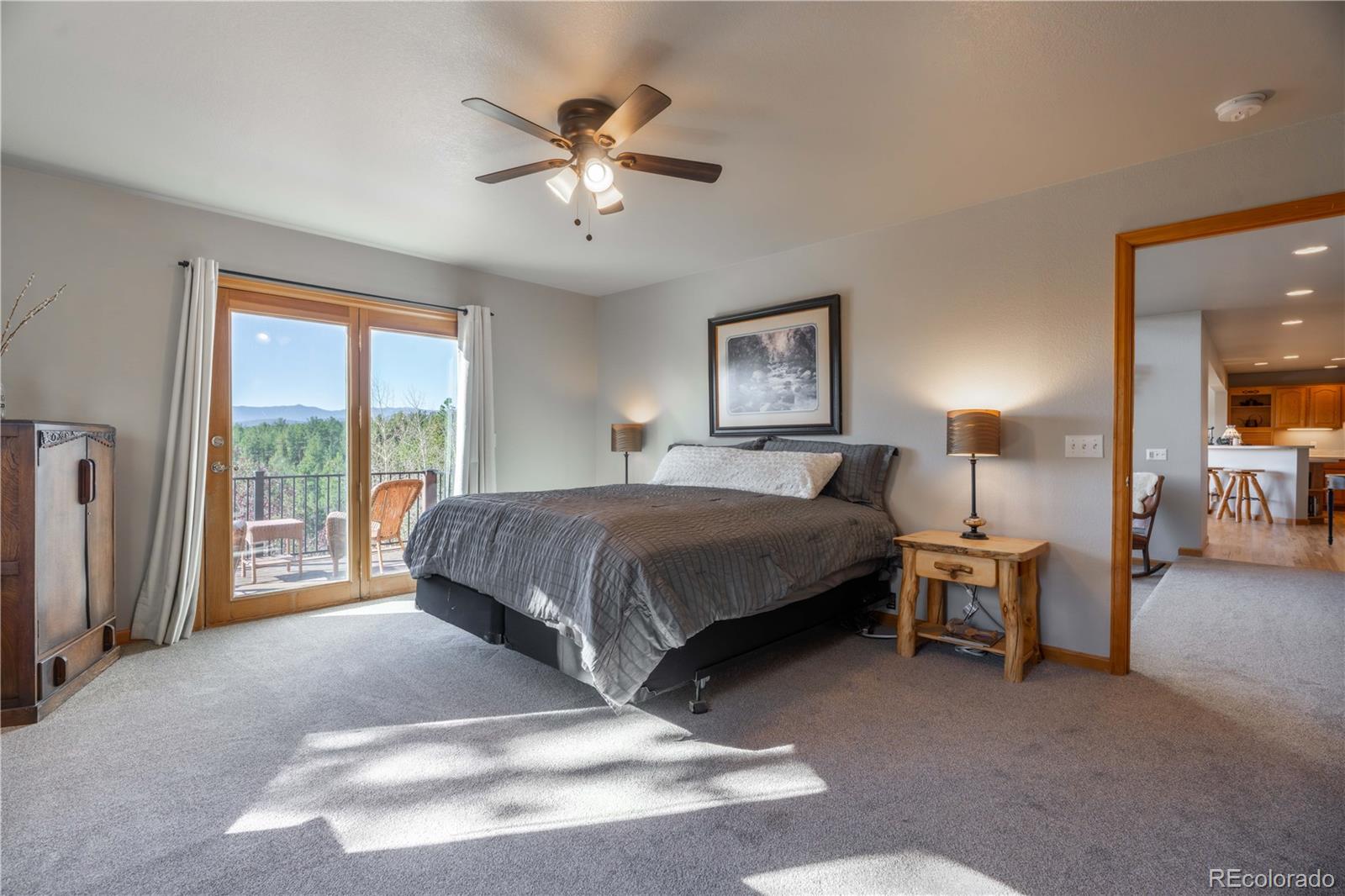 318 Rd D Pine, CO 80470 - Photo 26 of 50 a spacious bedroom with a bed a chandelier and a couch