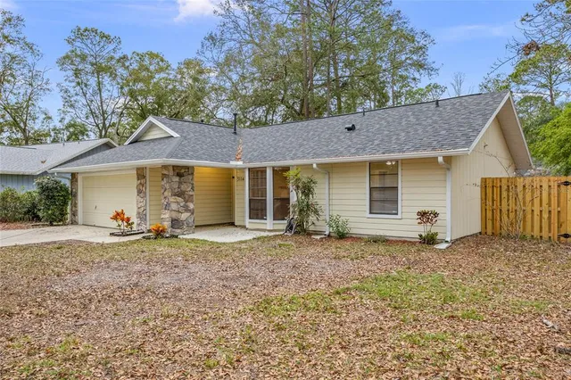 a view of a house with a yard and large tree