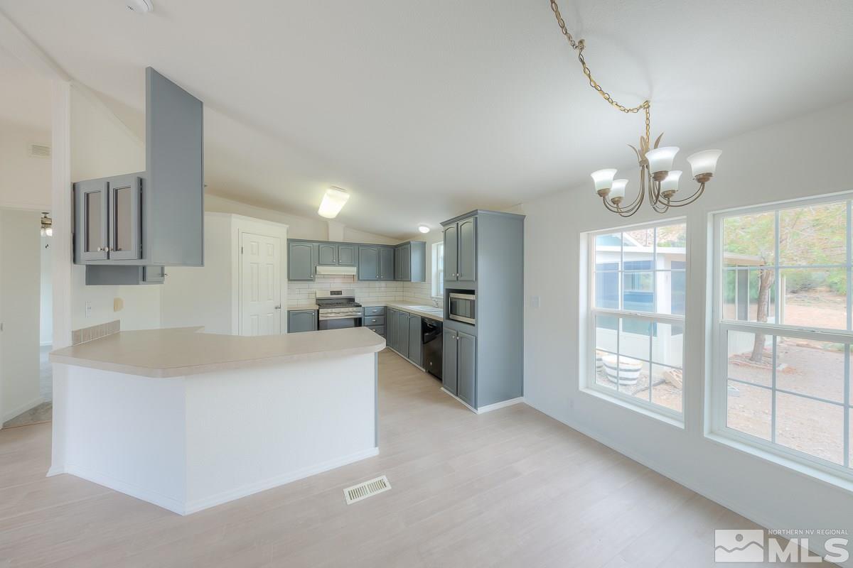 15186 Pinion Drive Reno, NV 89521 - Photo 8 of 20 a living room with stainless steel appliances furniture a chandelier and a large window