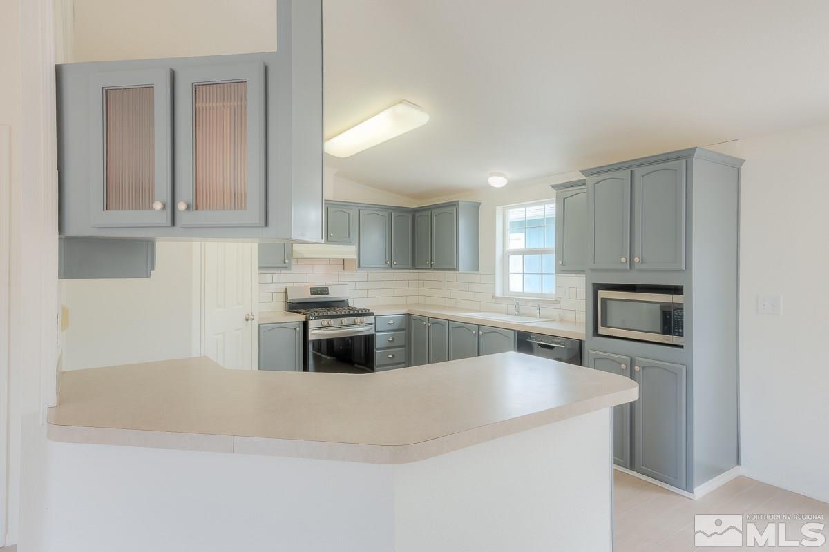 15186 Pinion Drive Reno, NV 89521 - Photo 9 of 20 a kitchen with granite countertop a stove a sink and a refrigerator