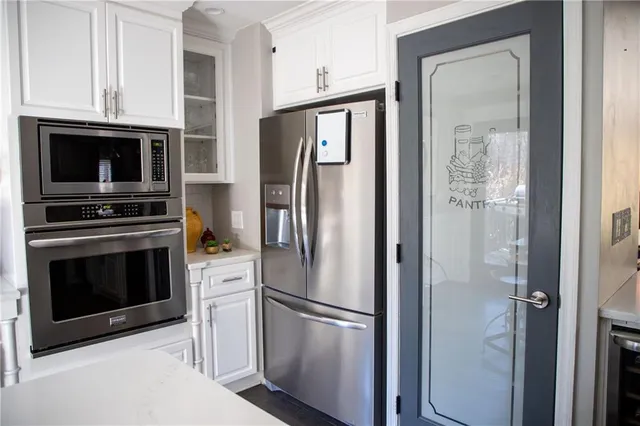 a metallic refrigerator freezer and a stove sitting inside of a kitchen