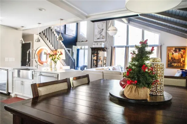 a living room with couches painting on the wall and a large window