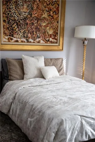 a bedroom with a bed and a lamp on dresser