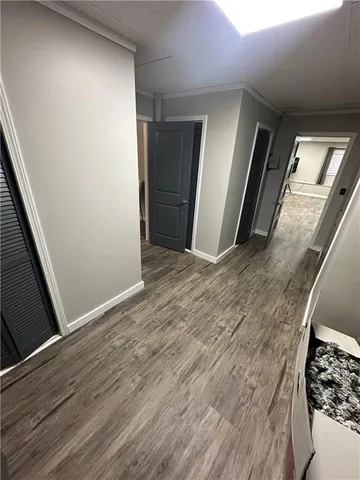 a view of a hallway with wooden floor and stairs