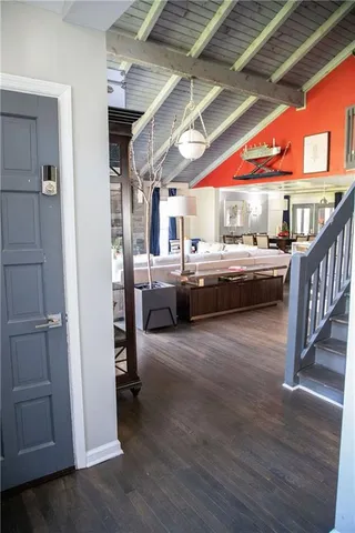 a living room with stainless steel appliances furniture floors and a kitchen view