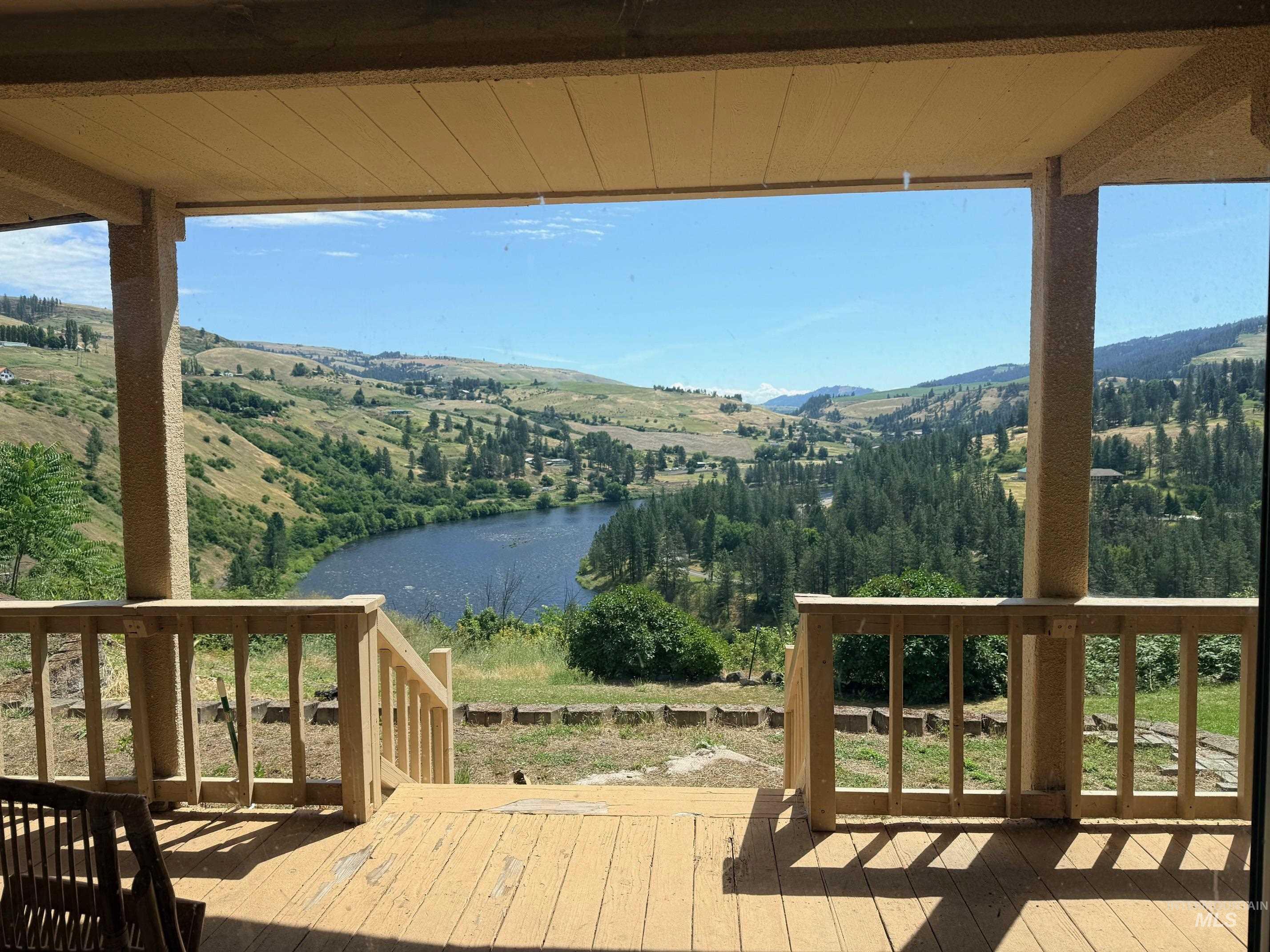 35322 River Road Lenore, ID 83541 - Photo 11 of 42 Covered patio with wood-finish decking and railing overlooking a river and expansive hillsides
