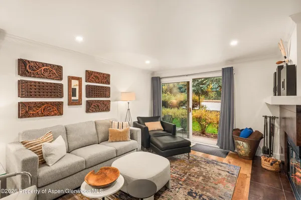 a living room with furniture and a floor to ceiling window