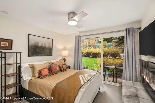 a bedroom with a large bed and a flat tv screen on dresser
