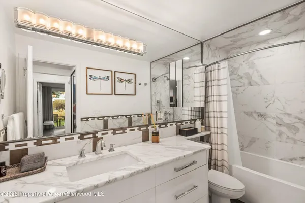a bathroom with a granite countertop sink mirror toilet and bathtub