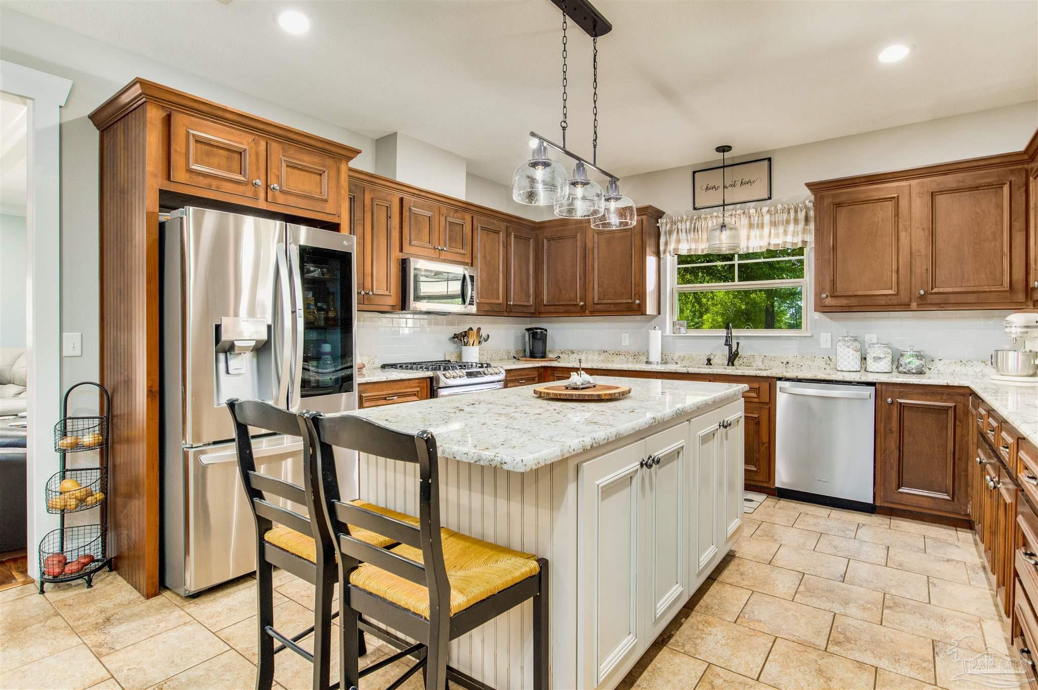 7223 Martin Road Milton, FL 32570 - Photo 12 of 27 a kitchen with a refrigerator a sink and cabinets