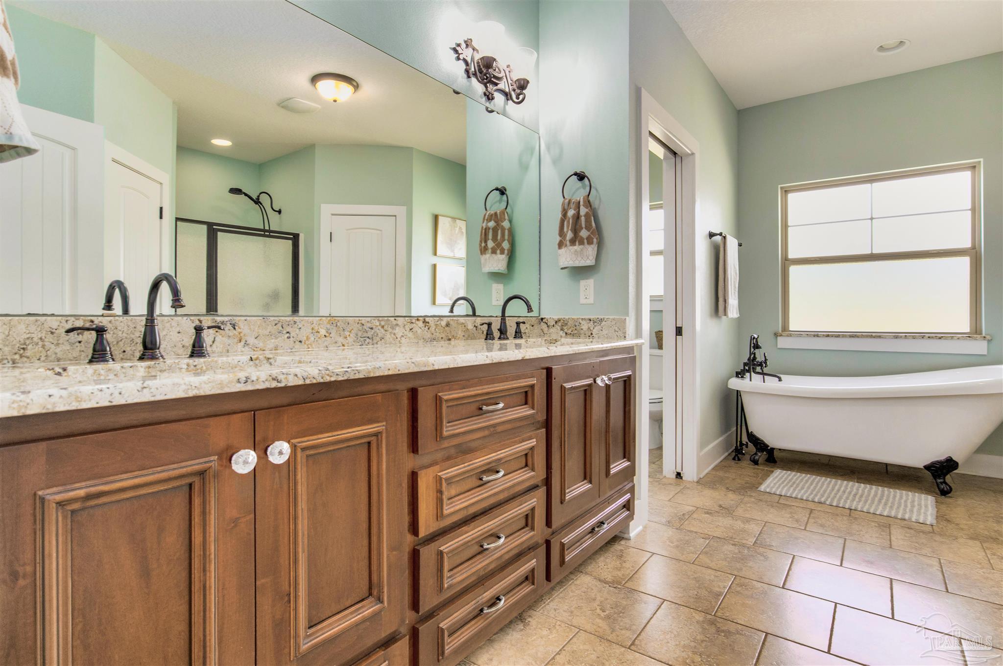 7223 Martin Road Milton, FL 32570 - Photo 15 of 27 a spacious bathroom with a granite countertop sink a mirror and a bathtub