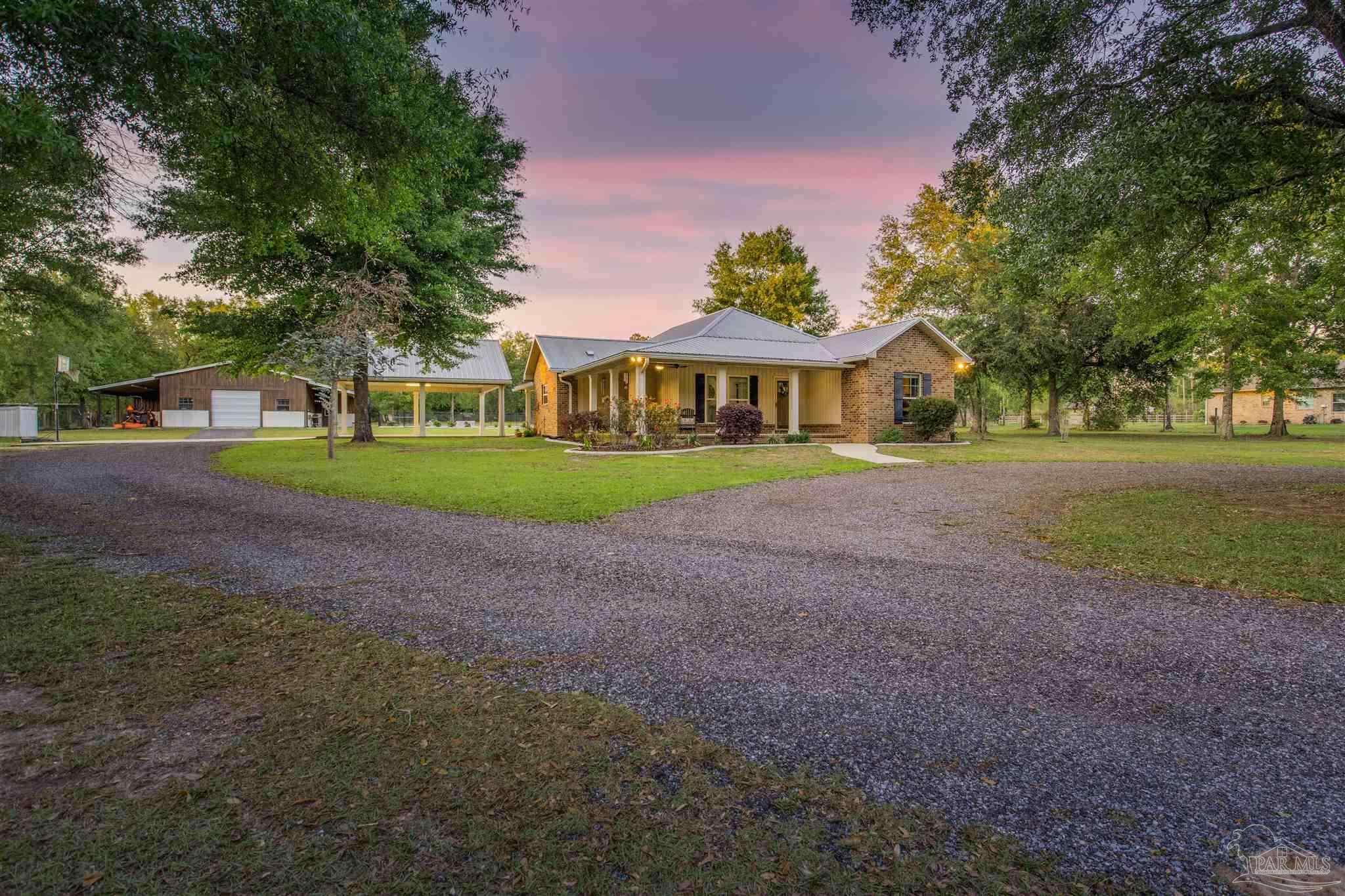 7223 Martin Road Milton, FL 32570 - Photo 2 of 27 a front view of a house with a yard and trees