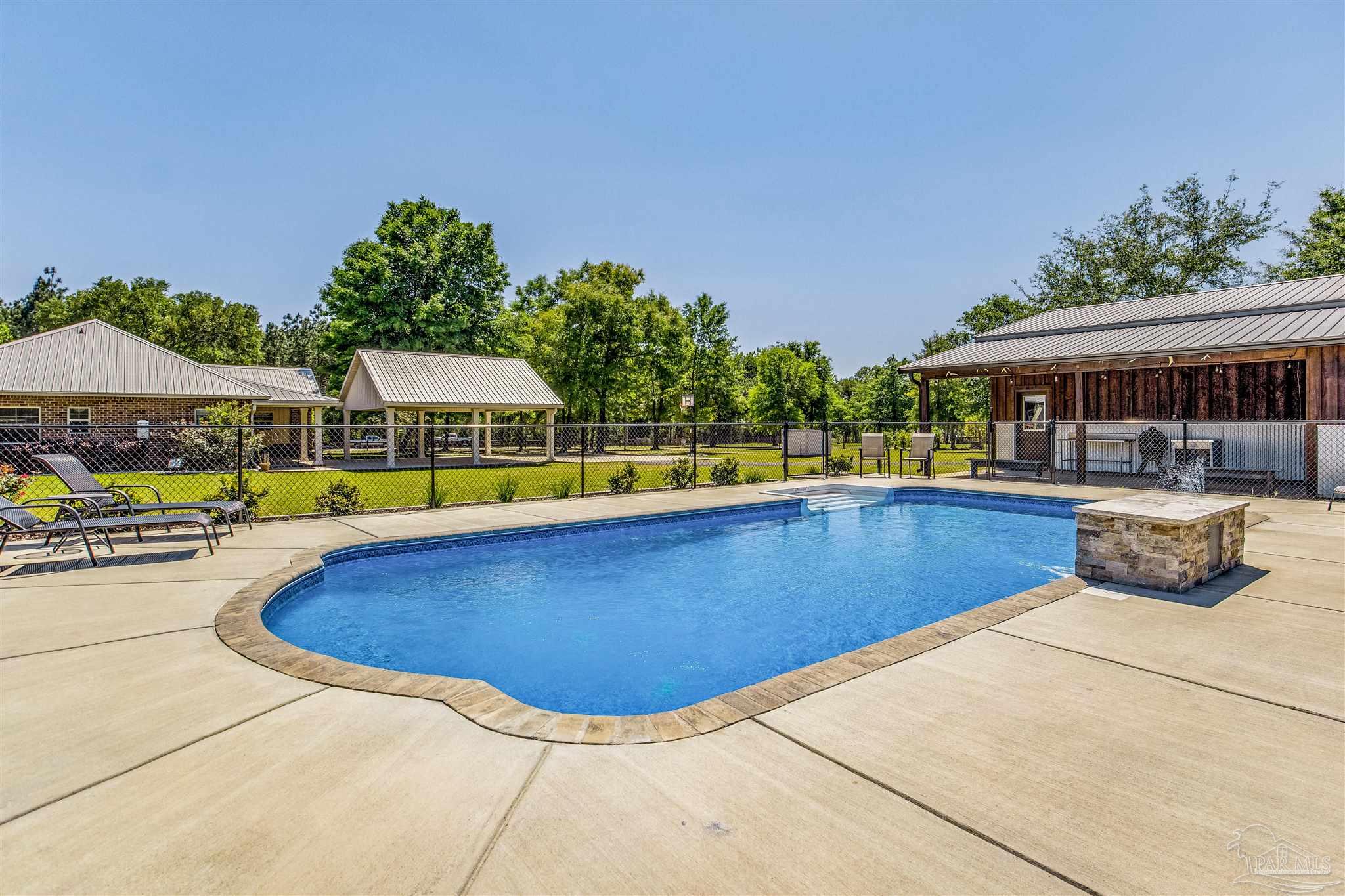 7223 Martin Road Milton, FL 32570 - Photo 21 of 27 a view of a swimming pool with an outdoor seating and yard