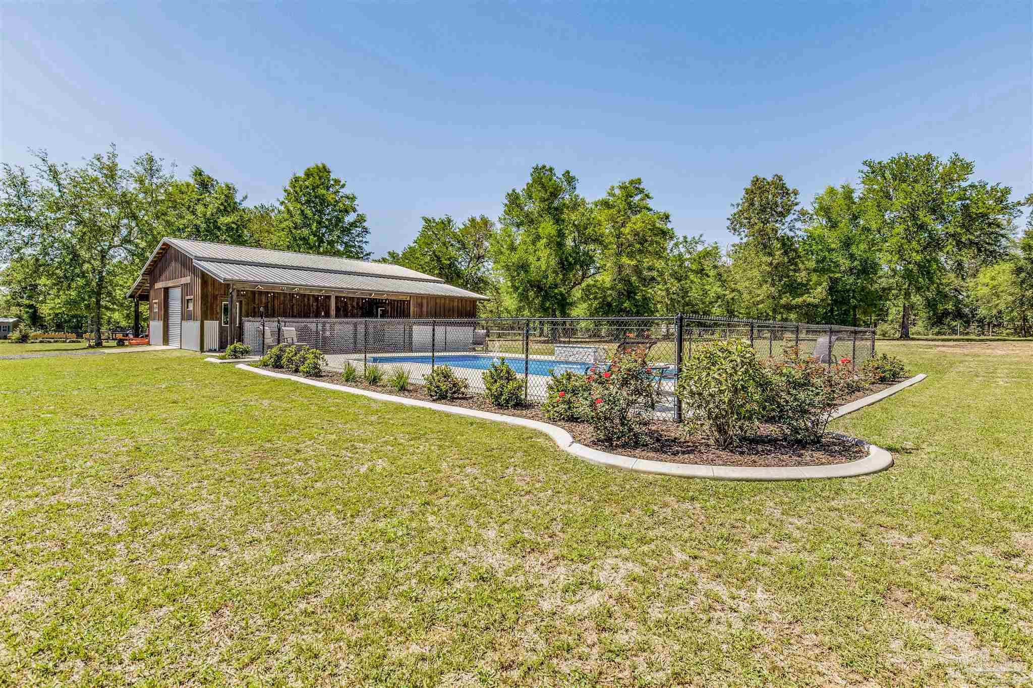 7223 Martin Road Milton, FL 32570 - Photo 23 of 27 a swimming pool with outdoor seating and garden