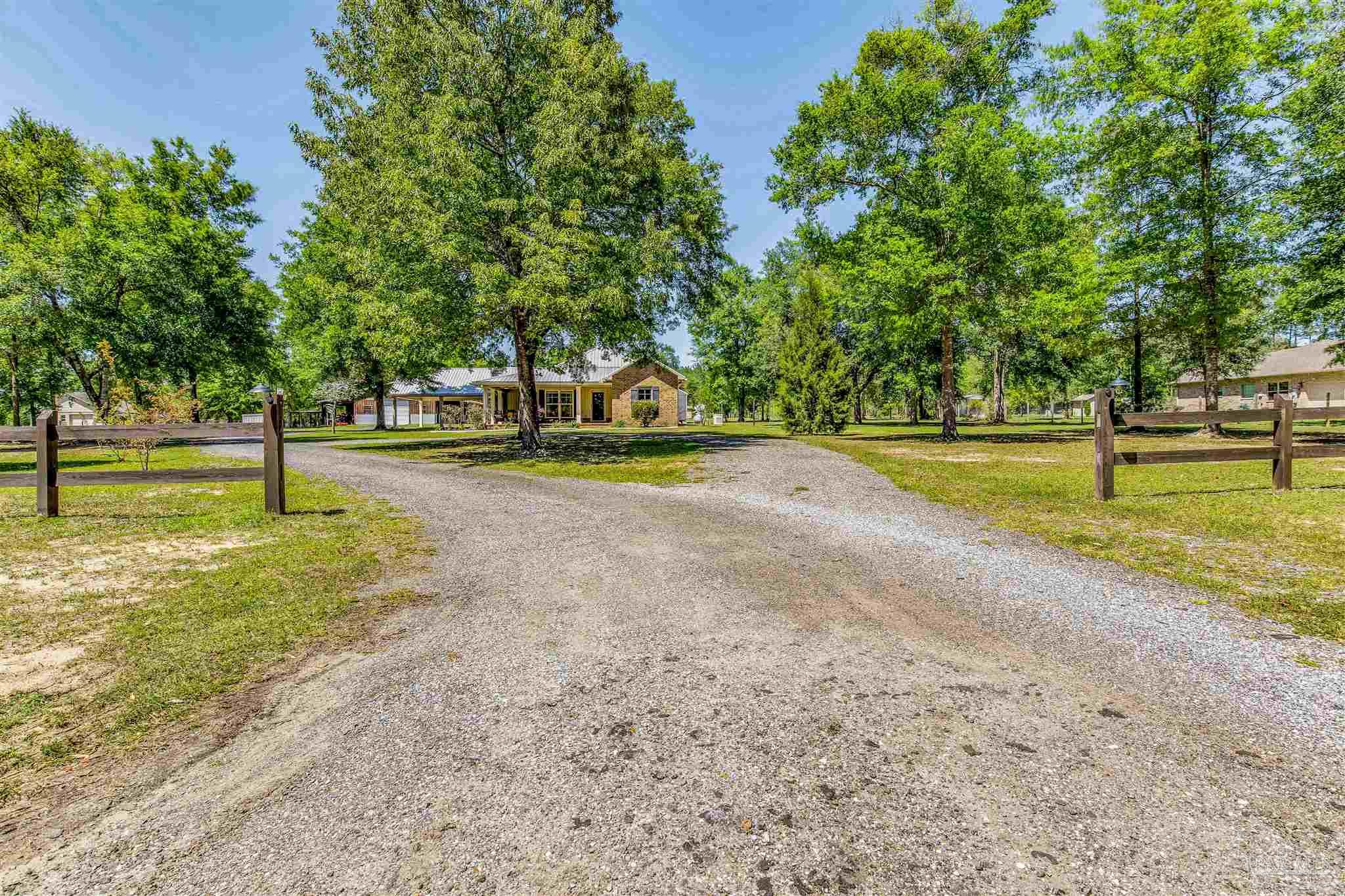 7223 Martin Road Milton, FL 32570 - Photo 3 of 27 a view of a yard with swimming pool and trees in the background