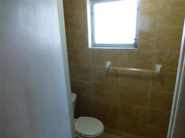 a white toilet sitting next to a window