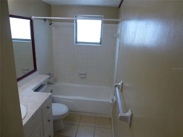 a bathroom with a granite countertop toilet a sink and bathtub