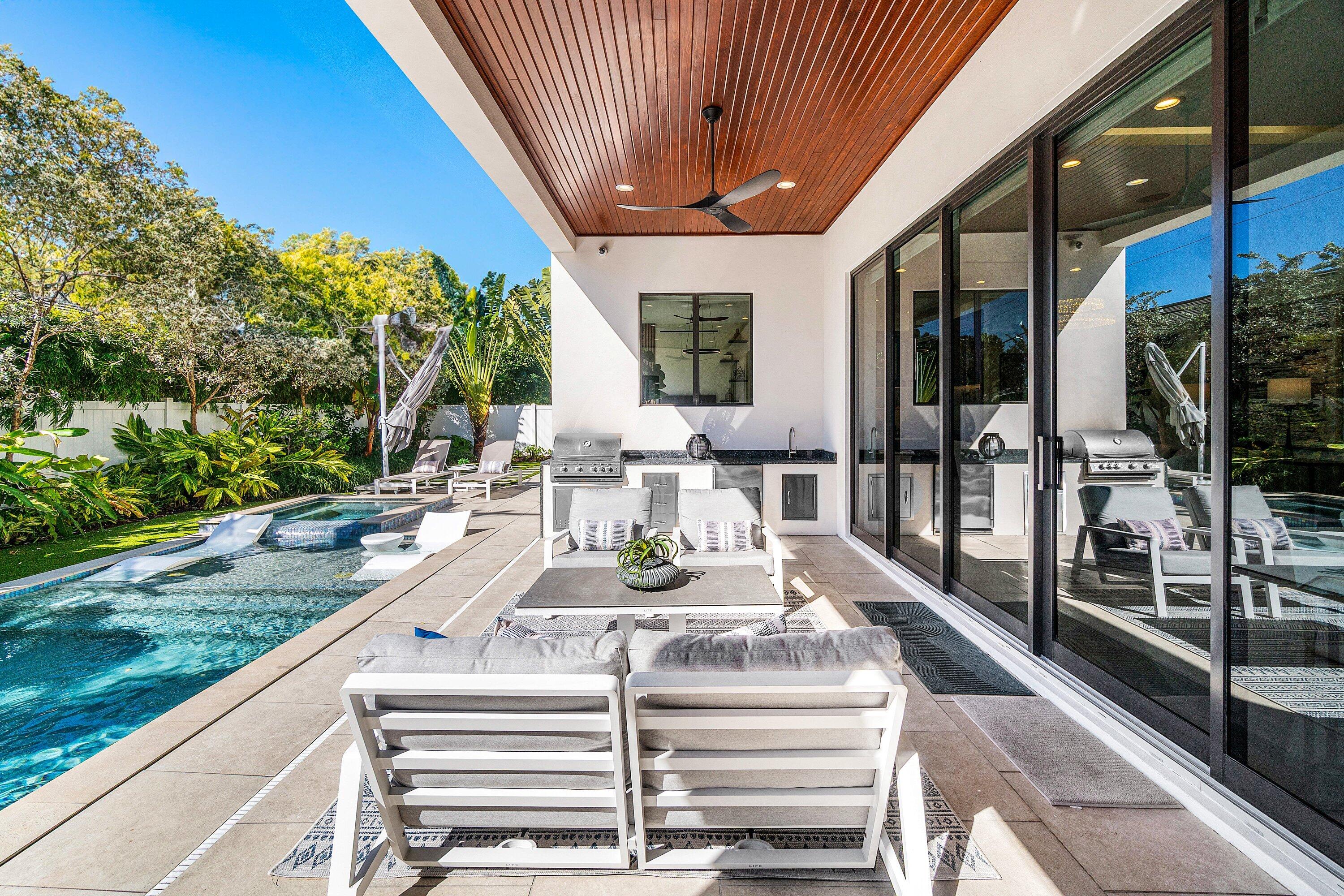 450 Northeast 10th Street Boca Raton, FL 33432 - Photo 115 of 119 a view of a patio with table and chairs potted plants with floor to ceiling window