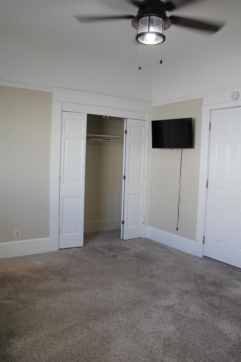 331 North 6th Street Fowler, CA 93625 - Photo 10 of 31 an empty room with a ceiling fan and window