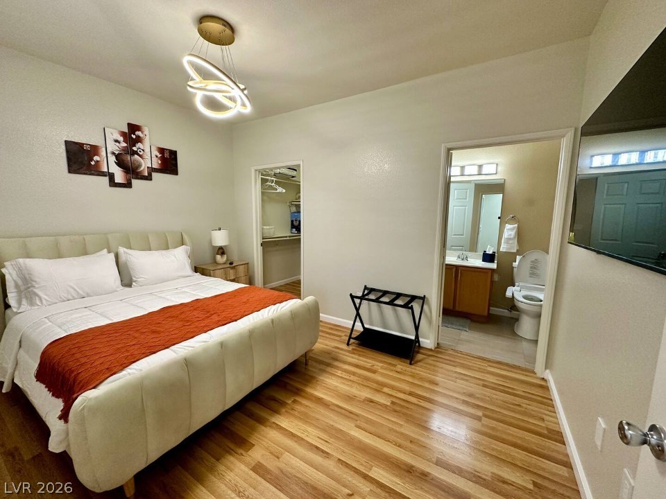 9580 West Reno Avenue, Unit 169 Las Vegas, NV 89148 - Photo 7 of 15 Hardwood floors lead to an open closet and a conveniently adjacent bathroom, creating a seamless private retreat.