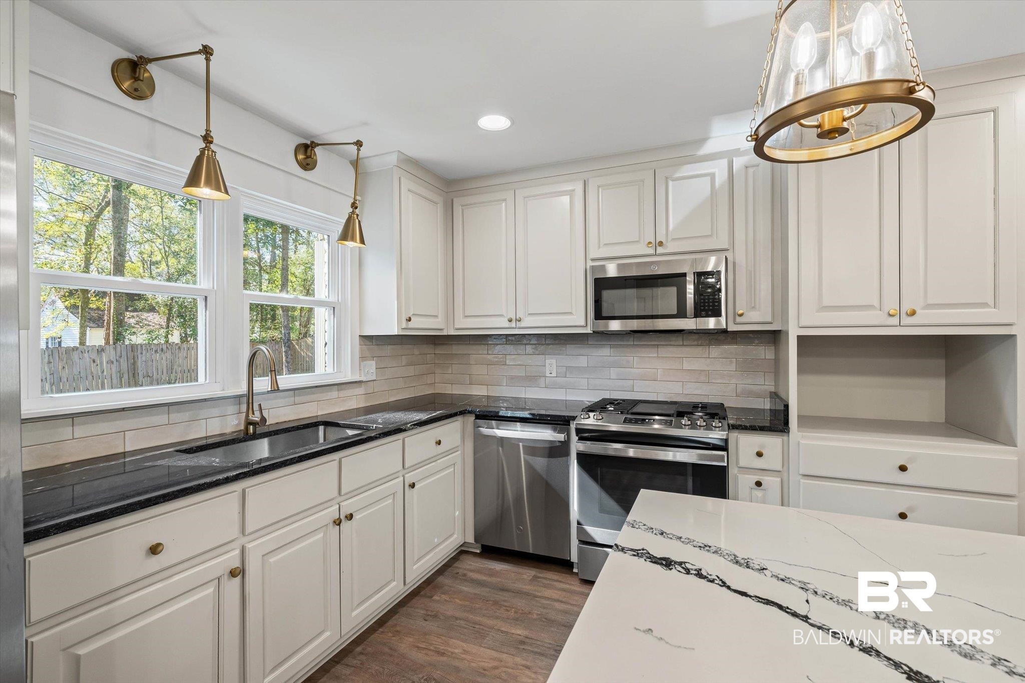 3933 Radnor Avenue Mobile, AL 36608 - Photo 12 of 36 Want this Kitchen? It could be yours! Complete with the white stone counters, appliances with stainless steel finishes, decorative light fixtures, recessed lighting and decorative shelving ... See it today! Dont' miss the breakfast bar .. or lunch, snack?