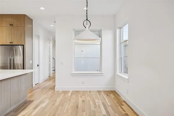 a view of empty room with wooden floor and window