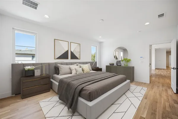 a bedroom with a large bed and a chandelier