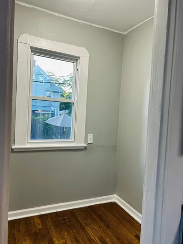 a view of a small space with wooden floor and a window