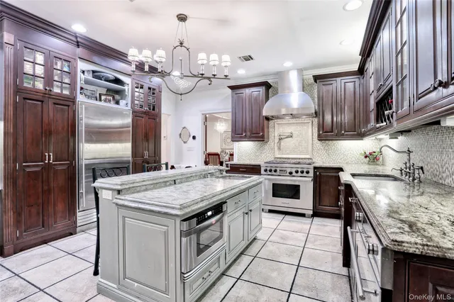 a kitchen with stainless steel appliances granite countertop a stove a sink and a refrigerator