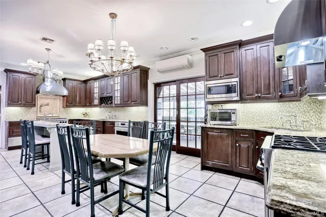 a kitchen with stainless steel appliances granite countertop table chairs microwave and cabinets