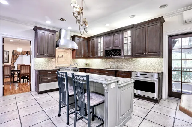 a kitchen with stainless steel appliances a stove a sink a microwave a refrigerator and chairs