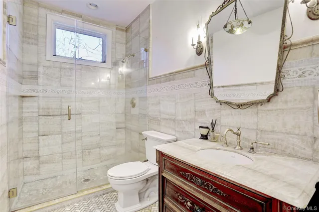 a bathroom with a granite countertop sink a toilet and a mirror