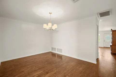 a view of a room with wooden floor and chandelier