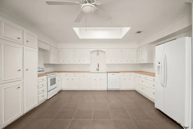 a large white kitchen with white cabinets