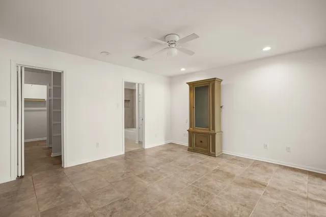 an empty room with closet and a ceiling fan